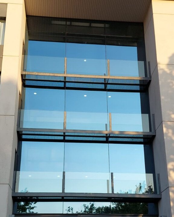 Fachada con grandes superficies acristaladas limpias en un edificio profesional de Madrid