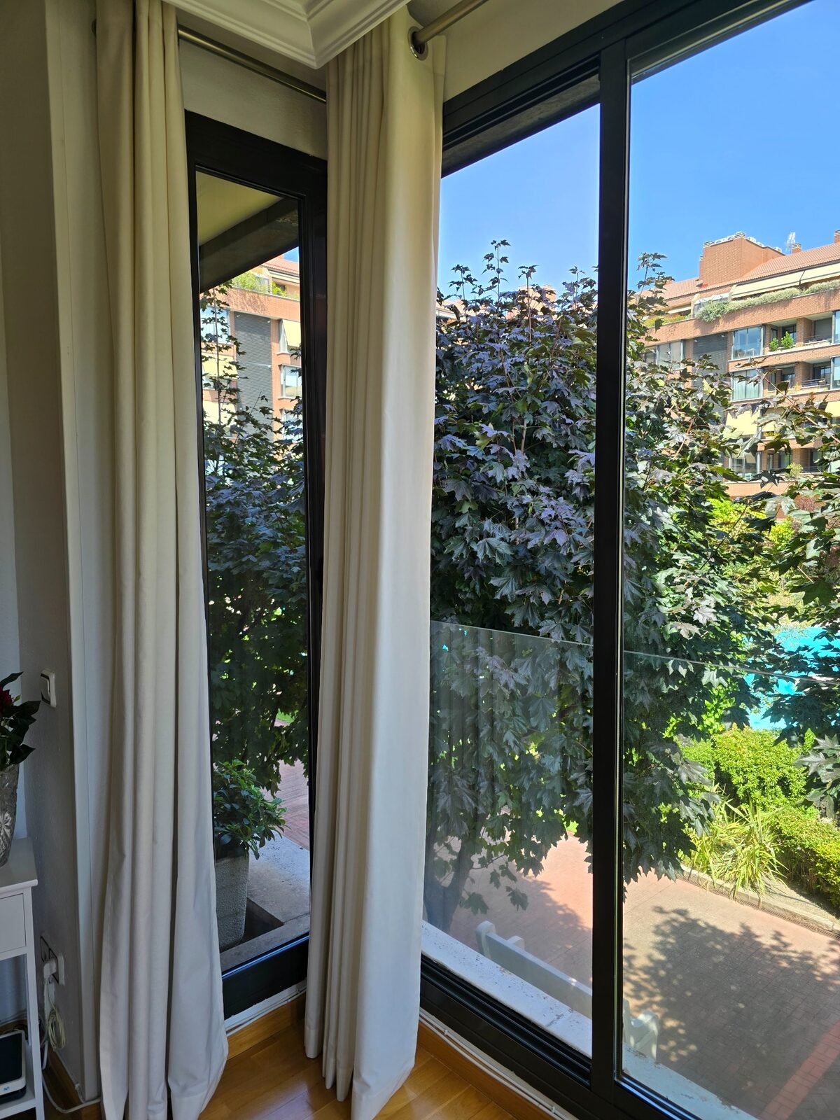 Ventanal limpio en una vivienda de Madrid con vistas a una zona ajardinada